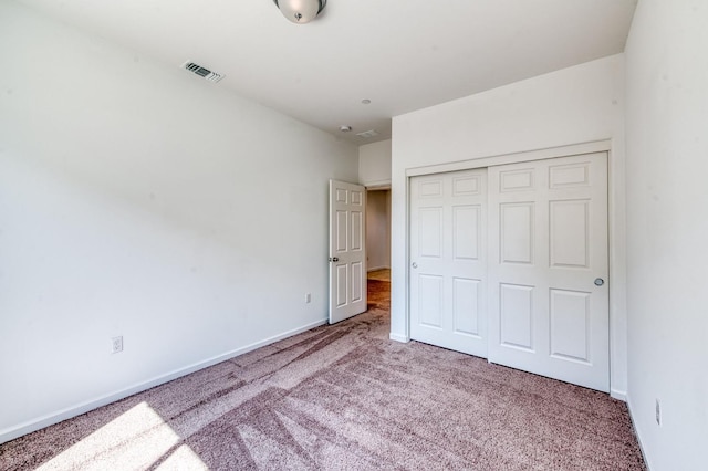 unfurnished bedroom featuring carpet flooring, a closet, and baseboards