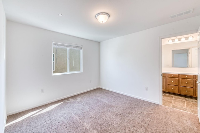 unfurnished bedroom with light carpet and baseboards