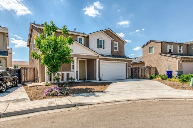 traditional home with a porch, fence, driveway, stucco siding, and a garage