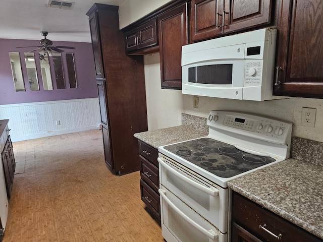 kitchen featuring white appliances, a ceiling fan, dark brown cabinetry, and wainscoting