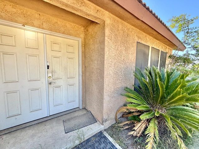 property entrance featuring stucco siding