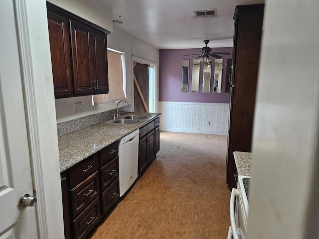 kitchen with a sink, dishwasher, wainscoting, a ceiling fan, and range