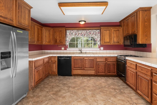 39976 Pierce Lake Dr, Oakhurst, CA 93644 - kitchen with black appliances, a sink, tile counters, and brown cabinets