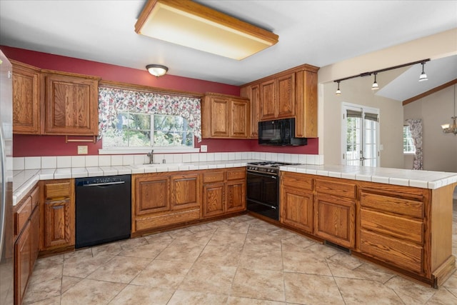 39976 Pierce Lake Dr, Oakhurst, CA 93644 - kitchen featuring black appliances, a sink, brown cabinetry, and a peninsula