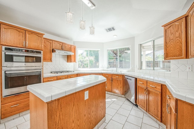 2113 E Portland Ave, Fresno, CA 93720 - kitchen featuring appliances with stainless steel finishes, under cabinet range hood, healthy amount of natural light, and a center island