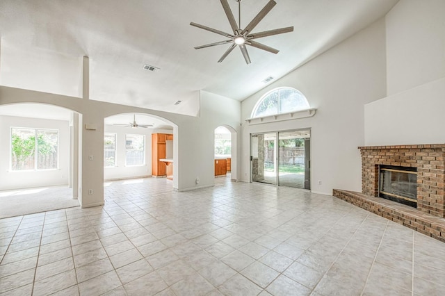 2113 E Portland Ave, Fresno, CA 93720 - unfurnished living room featuring a ceiling fan, a brick fireplace, high vaulted ceiling, arched walkways, and light tile patterned floors