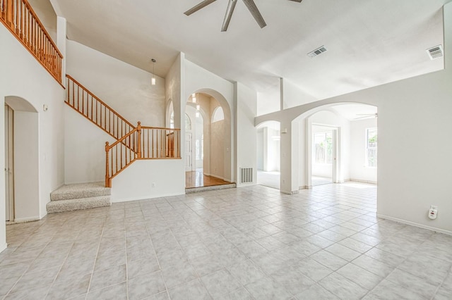 2113 E Portland Ave, Fresno, CA 93720 - unfurnished living room with a ceiling fan, stairs, arched walkways, a towering ceiling, and light tile patterned floors
