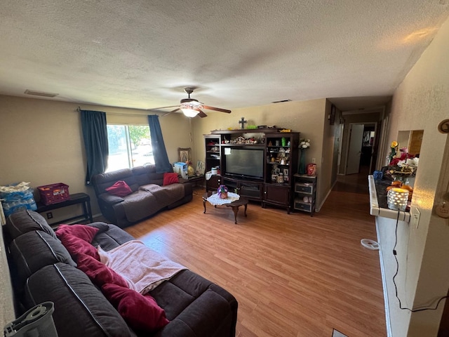 living room featuring a textured ceiling, wood finished floors, and a ceiling fan