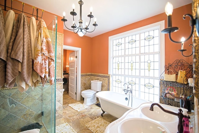 340 N Fulton St, Fresno, CA 93701 - full bathroom with washer / clothes dryer, tile walls, a chandelier, a shower stall, and a freestanding tub