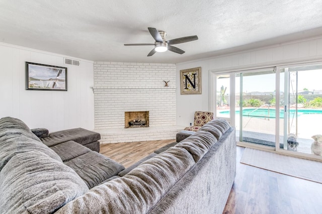 5932 E Illinois Ave, Fresno, CA 93727 - living area with wood finished floors, ceiling fan, a textured ceiling, and a fireplace