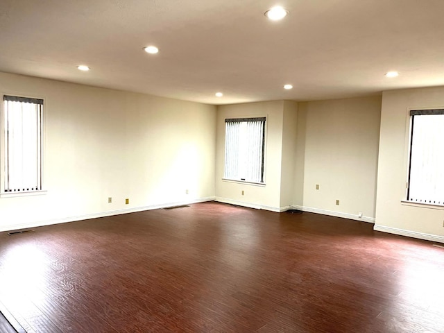 spare room with recessed lighting, dark wood-style floors, and baseboards