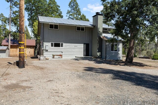 42640 Pinecone Ln, Auberry, CA 93602 - view of front of house featuring a chimney, metal roof, and dirt driveway