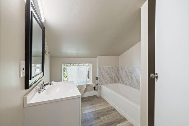 42640 Pinecone Ln, Auberry, CA 93602 - full bathroom featuring vaulted ceiling, a bathtub, vanity, wood finished floors, and baseboards