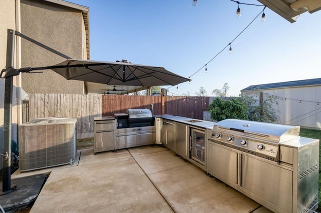 99 N Whittier Ave, Fresno, CA 93727 - view of patio featuring a grill, fence, exterior kitchen, and central air condition unit