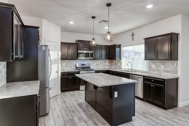 99 N Whittier Ave, Fresno, CA 93727 - kitchen with stainless steel appliances, a sink, a kitchen island, wood tiled floors, and recessed lighting