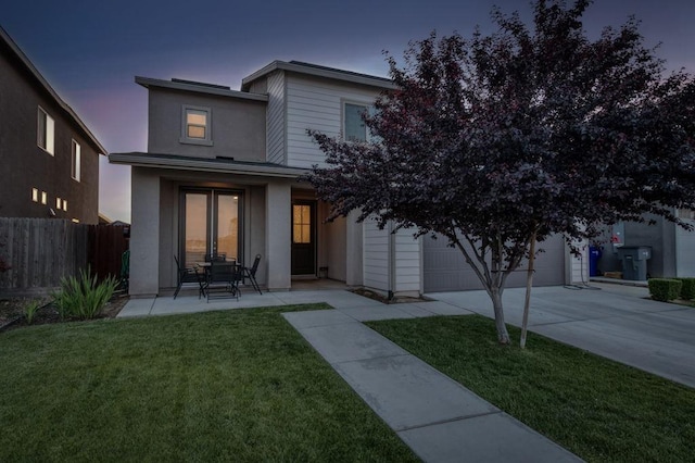 99 N Whittier Ave, Fresno, CA 93727 - back of house at dusk featuring concrete driveway, a garage, and stucco siding