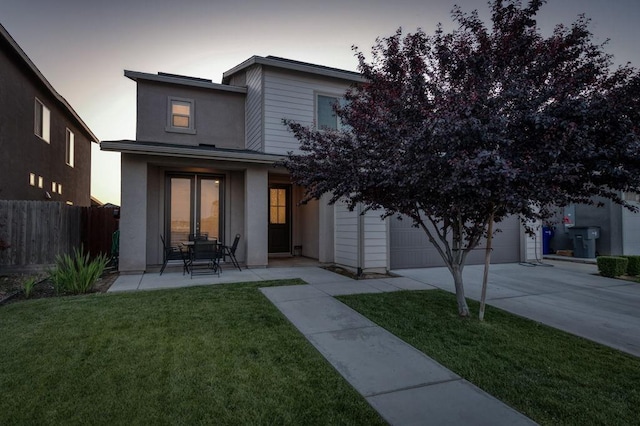 99 N Whittier Ave, Fresno, CA 93727 - back of property at dusk with concrete driveway, a garage, and stucco siding