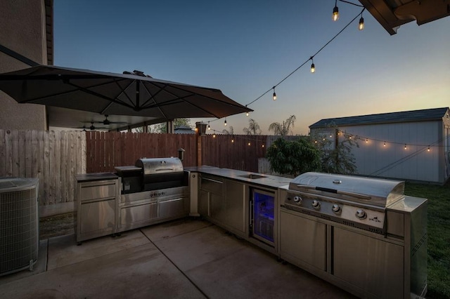99 N Whittier Ave, Fresno, CA 93727 - patio terrace at dusk with area for grilling, fence, central AC unit, and beverage cooler