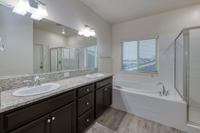 99 N Whittier Ave, Fresno, CA 93727 - full bathroom featuring a shower stall, a bath, double vanity, and wood finished floors