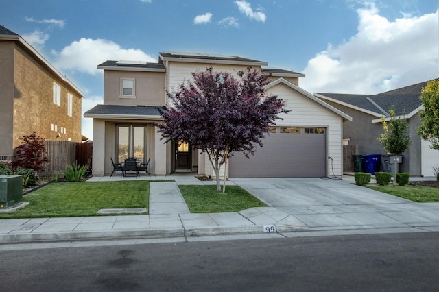 99 N Whittier Ave, Fresno, CA 93727 - view of front of property featuring roof mounted solar panels, driveway, a garage, and stucco siding