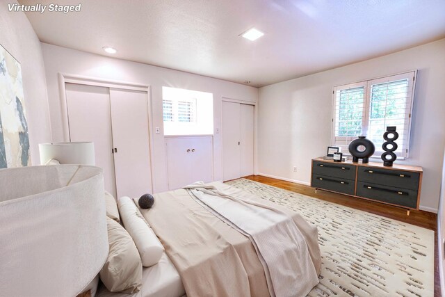 643 Park Ln, Madera, CA 93637 - bedroom featuring two closets, wood finished floors, multiple windows, and baseboards
