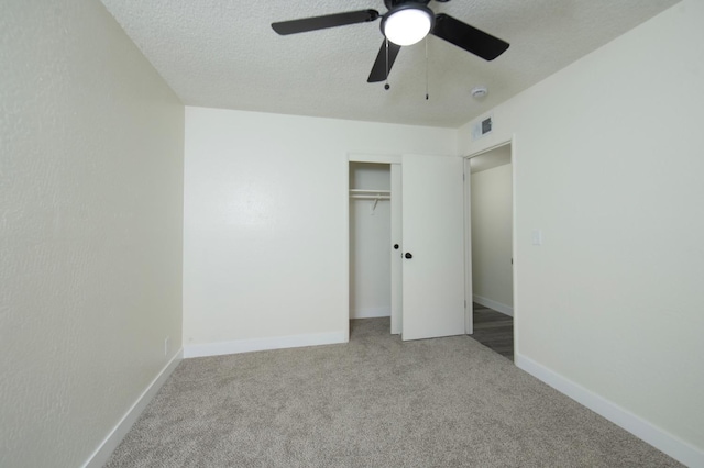 unfurnished bedroom with carpet, a closet, baseboards, a ceiling fan, and a textured ceiling