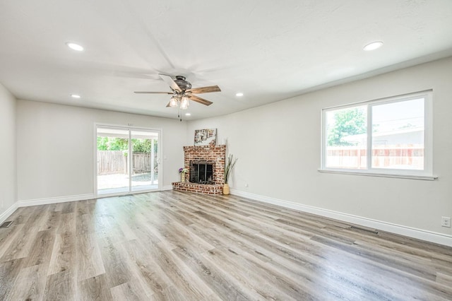 6117 N Colonial Ave, Fresno, CA 93704 - unfurnished living room with ceiling fan, recessed lighting, a brick fireplace, light wood finished floors, and baseboards