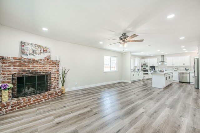 6117 N Colonial Ave, Fresno, CA 93704 - unfurnished living room with ceiling fan, recessed lighting, light wood finished floors, a fireplace, and baseboards