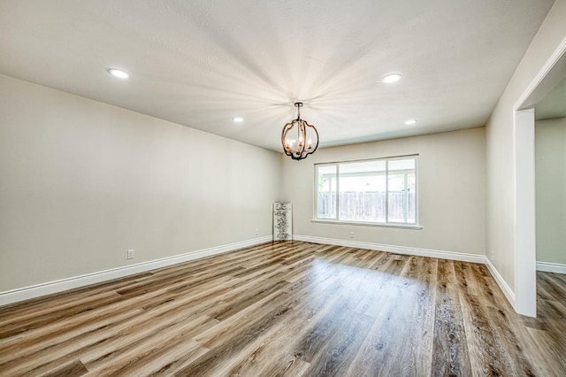 6117 N Colonial Ave, Fresno, CA 93704 - spare room featuring wood finished floors, baseboards, recessed lighting, and a chandelier
