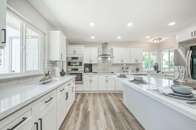 6117 N Colonial Ave, Fresno, CA 93704 - kitchen with wall chimney exhaust hood, appliances with stainless steel finishes, white cabinetry, backsplash, and recessed lighting