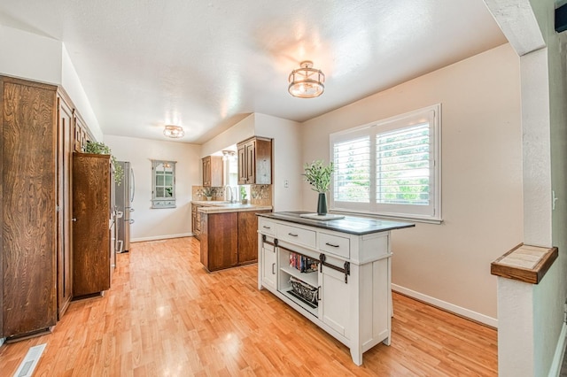 1487 W Paul Ave, Fresno, CA 93711 - kitchen with white cabinetry, light wood-style flooring, baseboards, and freestanding refrigerator