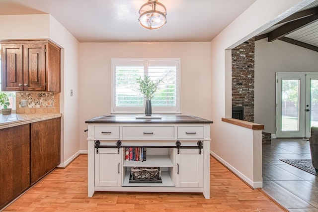1487 W Paul Ave, Fresno, CA 93711 - kitchen with light wood-style floors, white cabinets, tile countertops, decorative backsplash, and a large fireplace