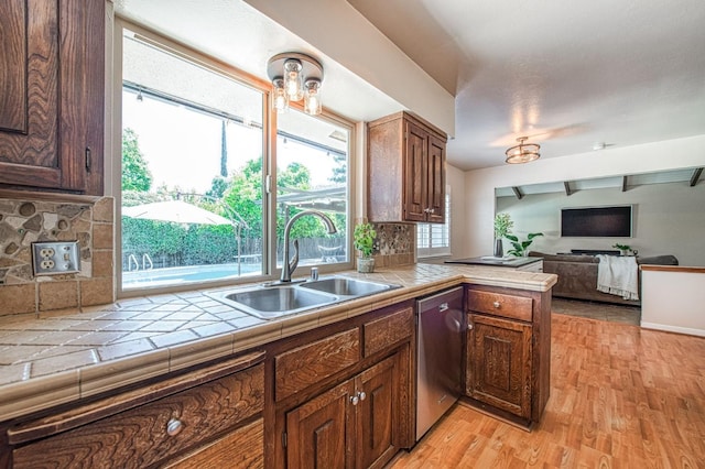 1487 W Paul Ave, Fresno, CA 93711 - kitchen with a sink, dishwasher, tile countertops, light wood-style flooring, and decorative backsplash