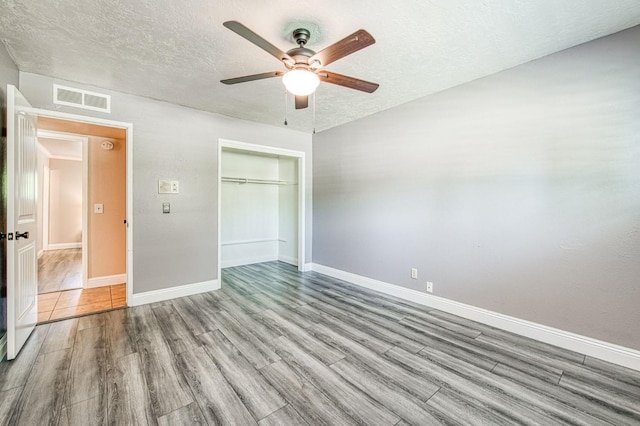 1487 W Paul Ave, Fresno, CA 93711 - unfurnished bedroom featuring wood finished floors, a textured ceiling, baseboards, a closet, and ceiling fan
