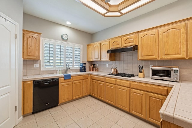 6423 N Bain Ave, Fresno, CA 93722 - kitchen featuring black appliances, under cabinet range hood, tile counters, a sink, and backsplash