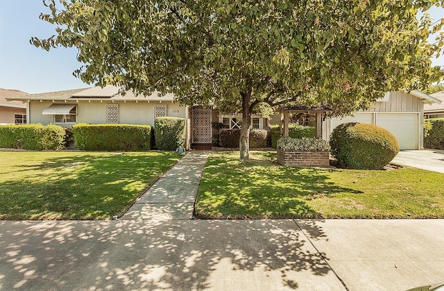 5082 N Maroa Ave, Fresno, CA 93704 - obstructed view of property featuring an attached garage, a front lawn, concrete driveway, and stucco siding