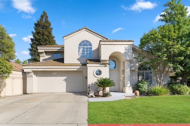 977 E Pennsylvania Ave, Fresno, CA 93720 - mediterranean / spanish-style home with stucco siding, driveway, an attached garage, and a front yard