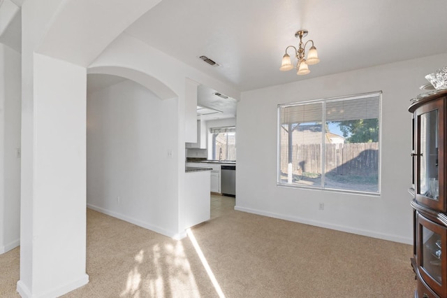 977 E Pennsylvania Ave, Fresno, CA 93720 - unfurnished dining area with light colored carpet, a chandelier, arched walkways, baseboards, and a sink