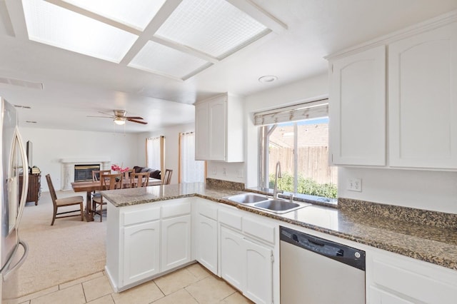 977 E Pennsylvania Ave, Fresno, CA 93720 - kitchen with dishwashing machine, a sink, ceiling fan, white cabinets, and a peninsula