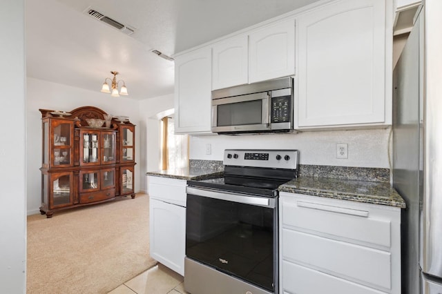 977 E Pennsylvania Ave, Fresno, CA 93720 - kitchen with appliances with stainless steel finishes, light carpet, a chandelier, and white cabinetry