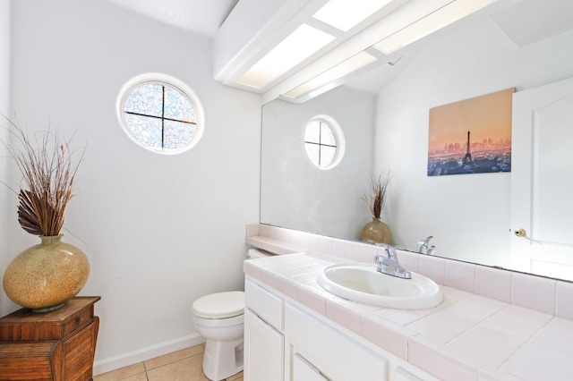 977 E Pennsylvania Ave, Fresno, CA 93720 - bathroom featuring healthy amount of natural light, toilet, tile patterned floors, vanity, and vaulted ceiling