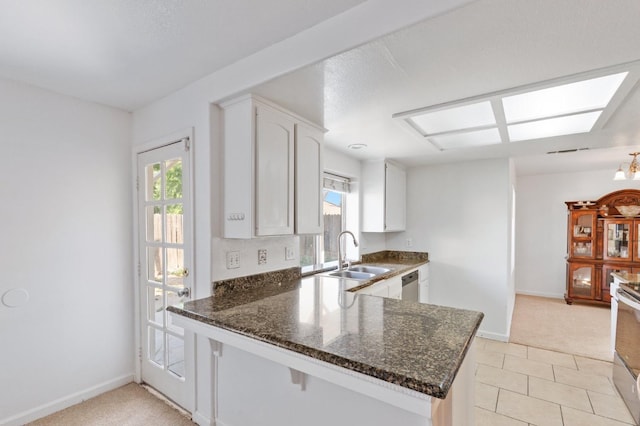 977 E Pennsylvania Ave, Fresno, CA 93720 - kitchen with a sink, stainless steel dishwasher, dark stone counters, and a peninsula