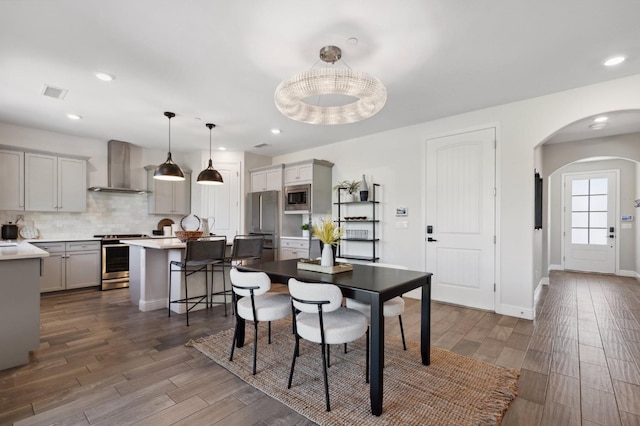 11289 N Alicante Dr, Fresno, CA 93730 - dining space featuring arched walkways, dark wood-style flooring, recessed lighting, and baseboards