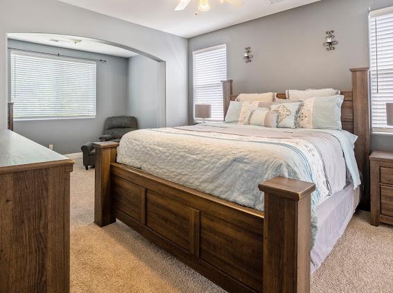 bedroom with light colored carpet and a ceiling fan