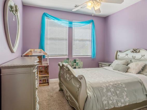 bedroom with light carpet, a ceiling fan, and baseboards
