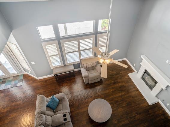 living room with healthy amount of natural light, baseboards, and wood finished floors