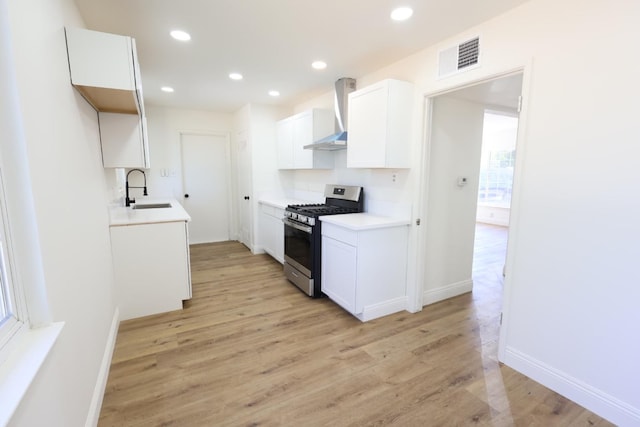 445 Shaw Ave, Clovis, CA 93612 - kitchen featuring gas stove, wall chimney range hood, a sink, light wood-type flooring, and recessed lighting