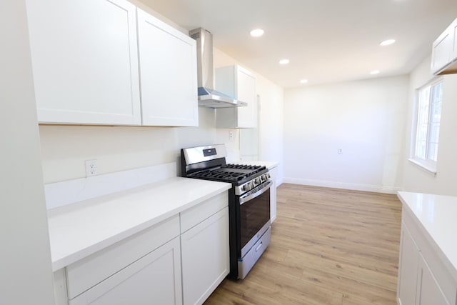 445 Shaw Ave, Clovis, CA 93612 - kitchen featuring stainless steel gas range, wall chimney exhaust hood, light wood-style flooring, white cabinetry, and recessed lighting