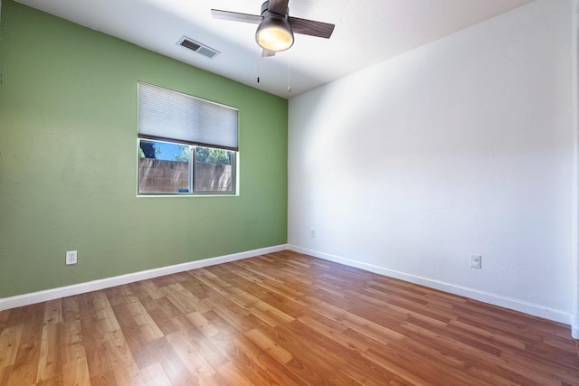 spare room featuring wood finished floors, ceiling fan, and baseboards