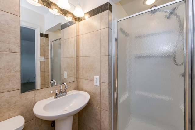 5535 N Millbrook Ave, Fresno, CA 93710 - full bath featuring tile walls, a stall shower, toilet, a sink, and backsplash
